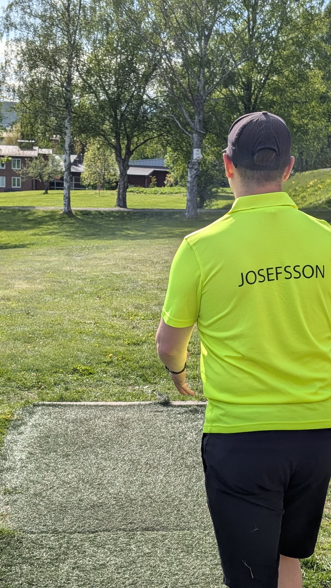 Spelare i Härnösands Discgolfclubs tröja på tee